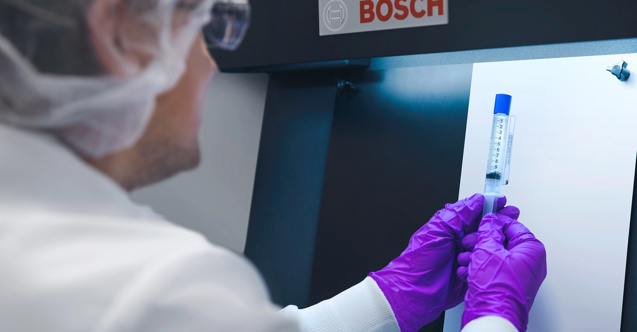 Pharmacist in laboratory holding a syringe 