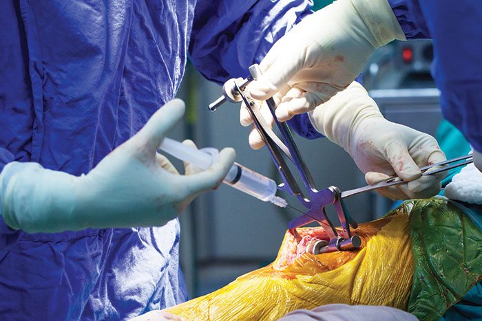 Knee surgery; the doctor administers an injection to the patient's knee.